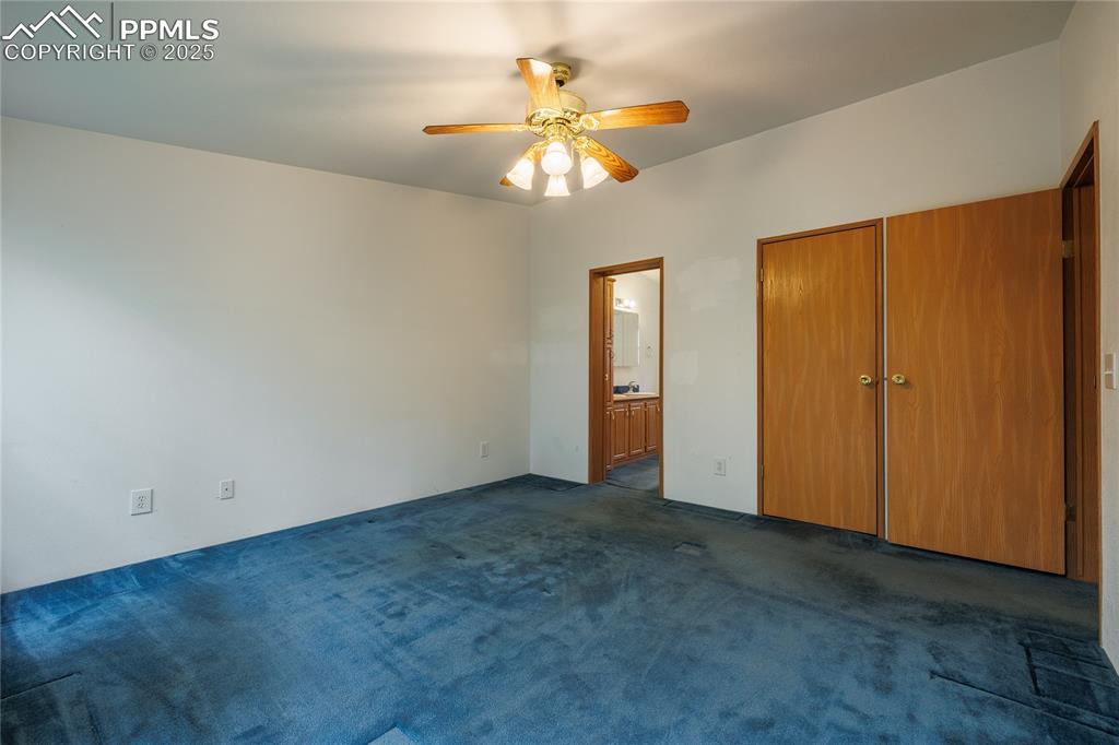 Image 26 of 26: Unfurnished bedroom featuring dark carpet, ensuite bathroom, and a ceiling 