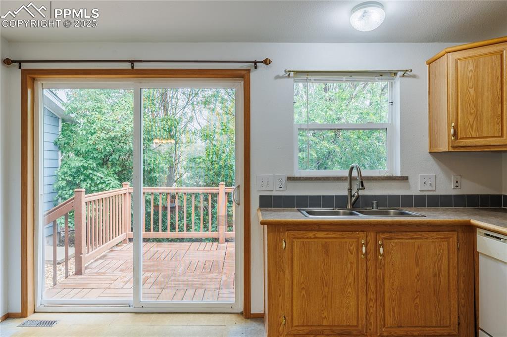 Image 5 of 26: Kitchen with a sink, dishwasher, and tile counters
