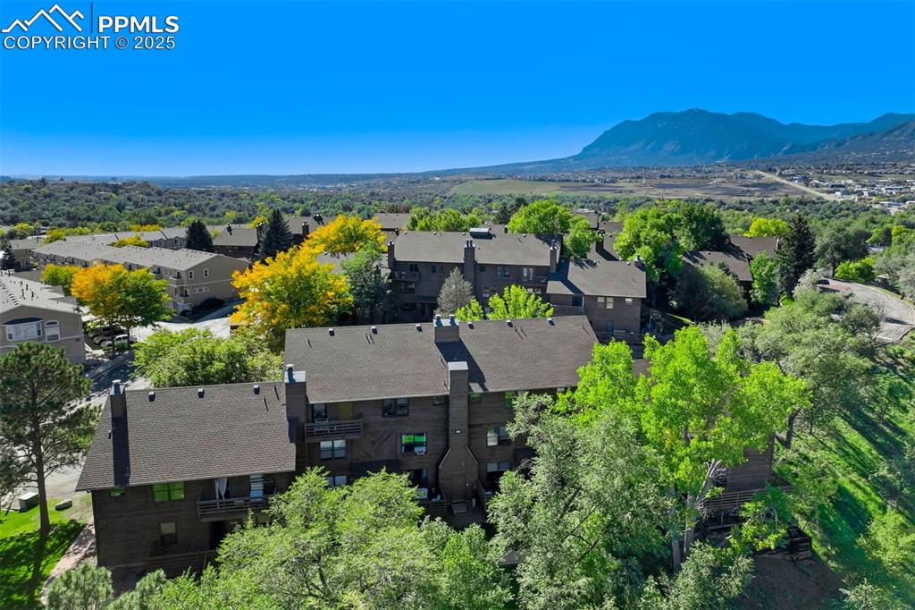 Image 28 of 35: Aerial view of residential area featuring a mountain backdrop