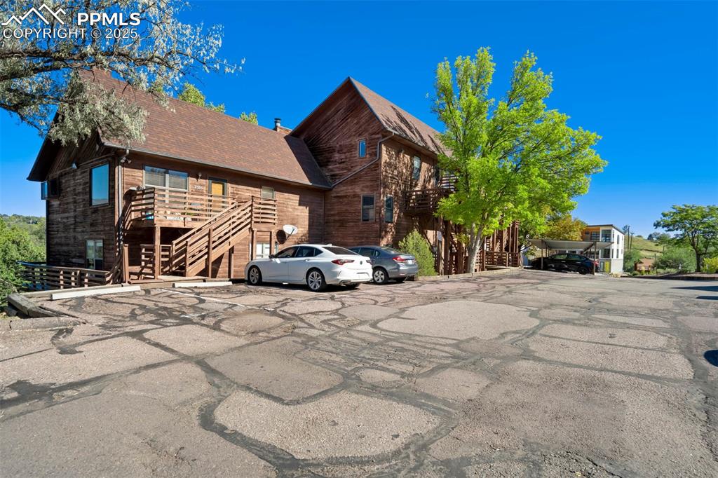 Image 5 of 35: View of front of property with stairway, roof with shingles, and uncovered 