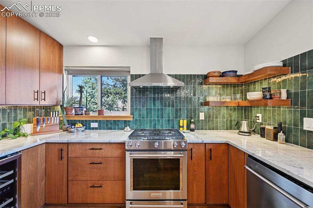 Image 14 of 42: Kitchen with gas burning stove, custom cabinetry, wine fridge, quartzite co