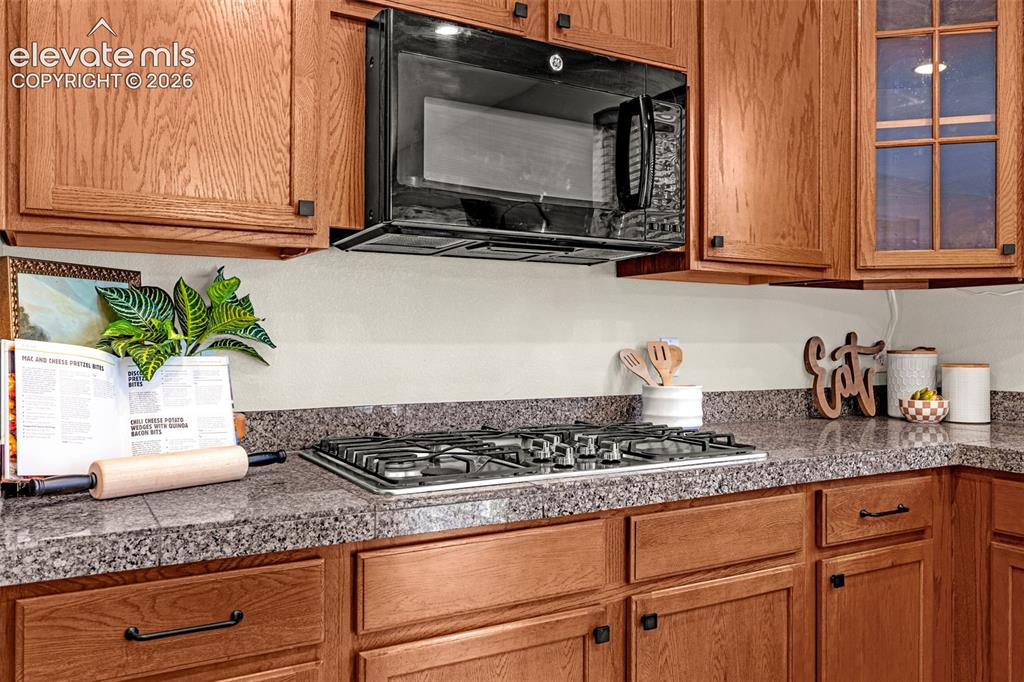 Image 16 of 44: Gas cooktop and overhead microwave