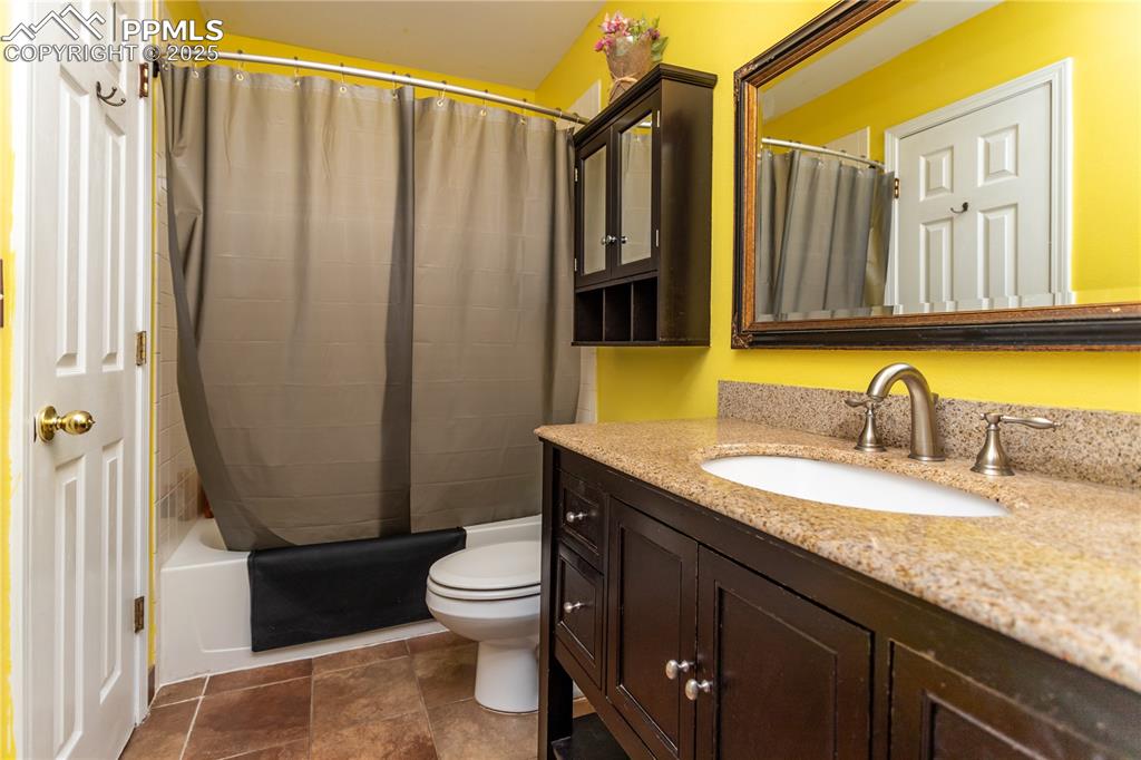 Image 23 of 50: Full bath with vanity, toilet, and shower / bathtub combination with curtai