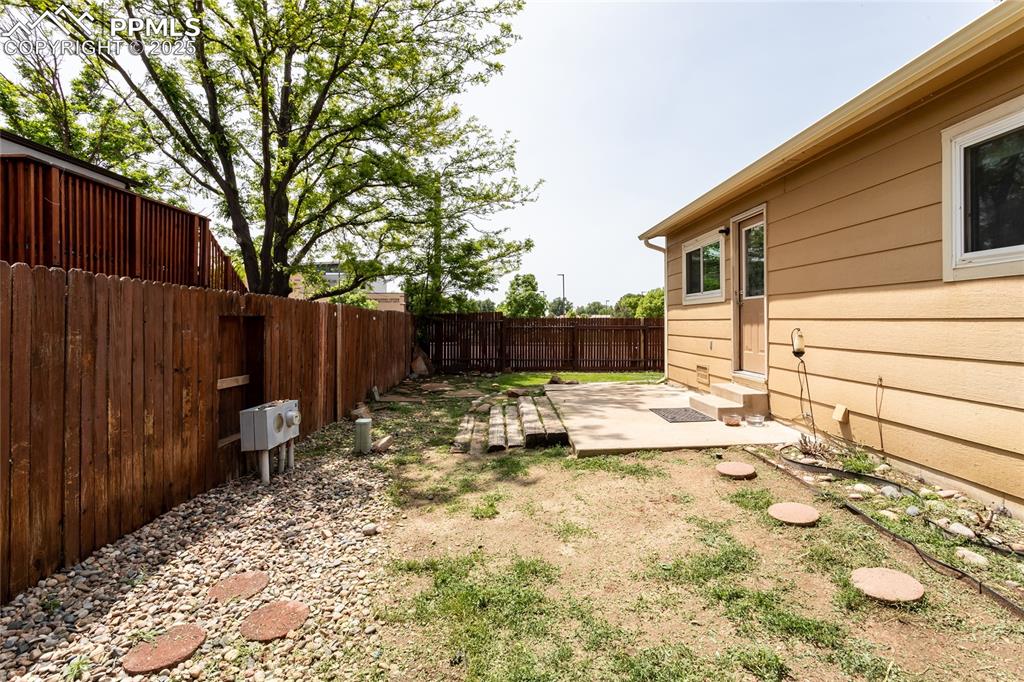 Image 25 of 50: Fenced backyard featuring entry steps and a patio area