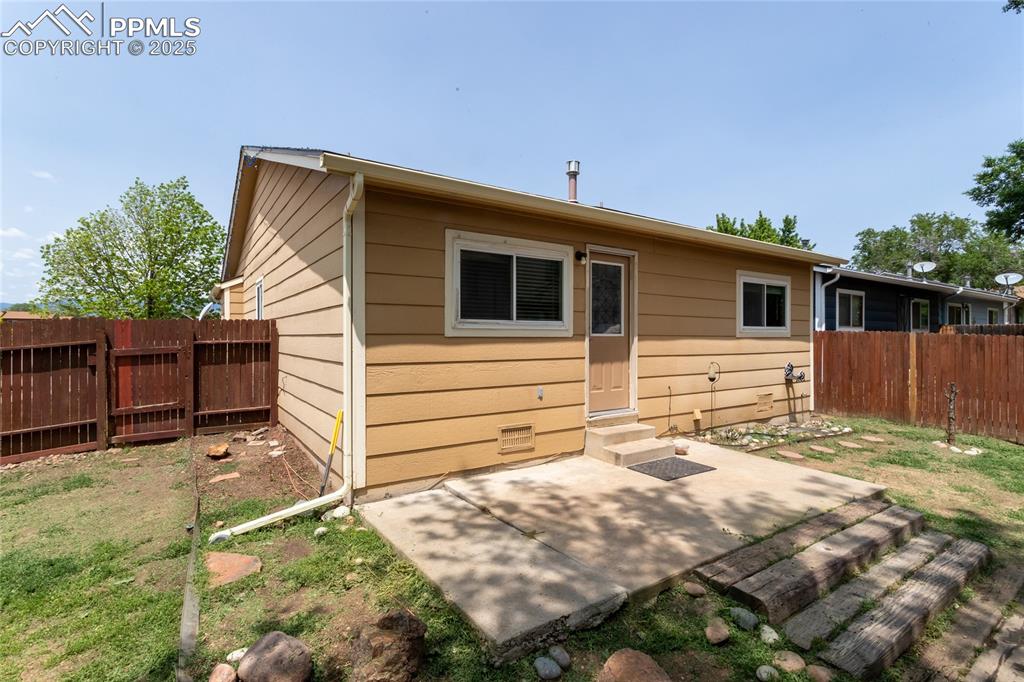 Image 26 of 50: Rear view of house featuring entry steps and a patio area