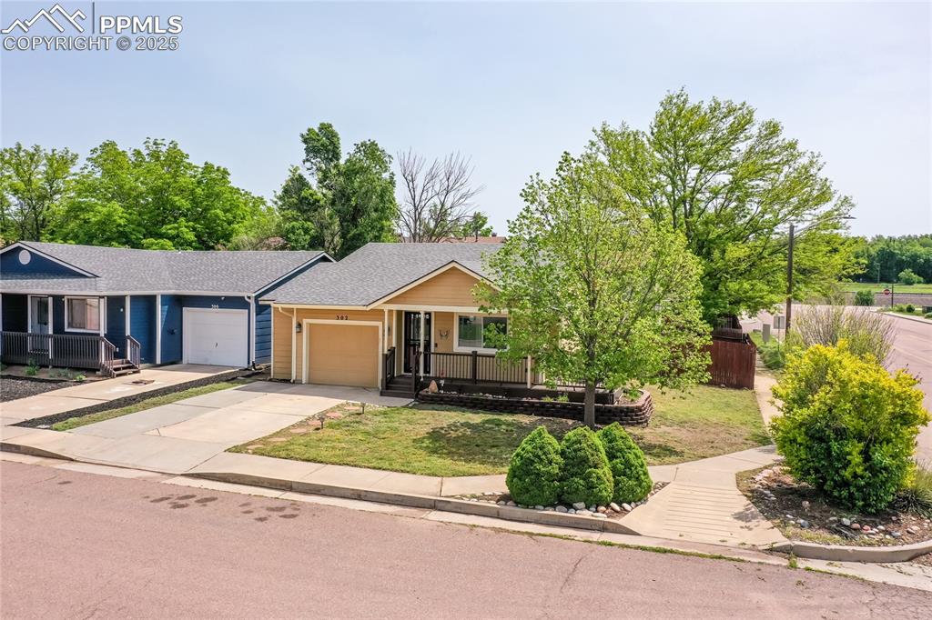 Image 3 of 50: View of front facade featuring a porch, a garage, concrete driveway, and ro