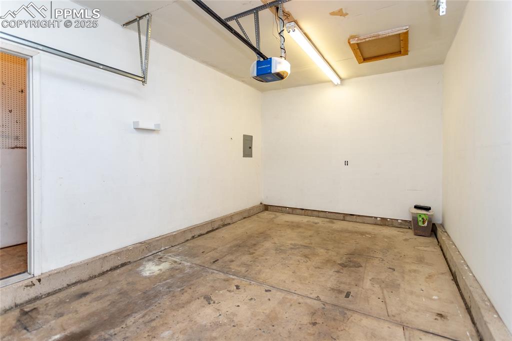 Image 30 of 50: Garage with a garage door opener and electric panel