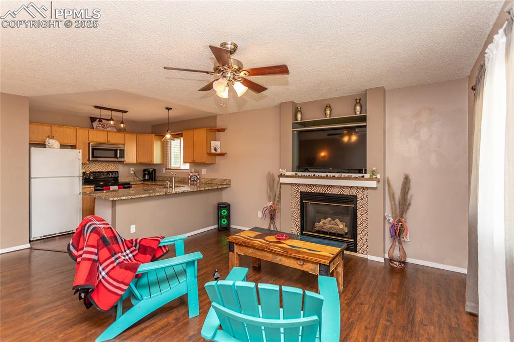 Image 36 of 50: Living room featuring a textured ceiling, dark wood-style flooring, a ceili