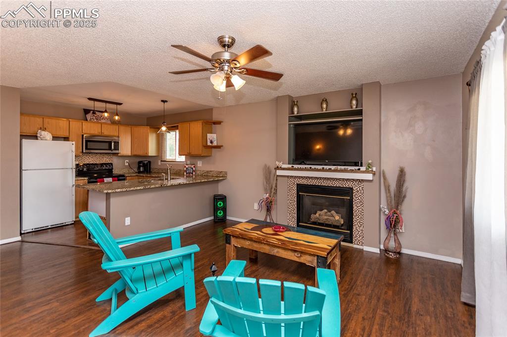 Image 46 of 50: Living area with a textured ceiling, dark wood finished floors, a ceiling f
