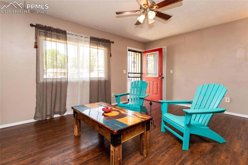 Image 48 of 50: Living area with a ceiling fan, wood finished floors, and baseboards