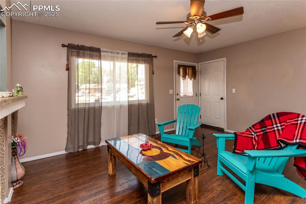 Image 50 of 50: Living area with a ceiling fan, wood finished floors, and baseboards