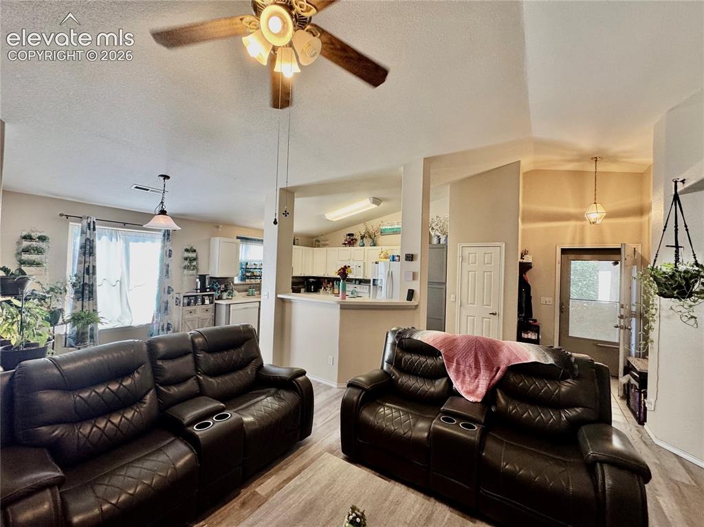 Image 11 of 32: Open concept living area featuring wood-finish flooring, a ceiling fan with