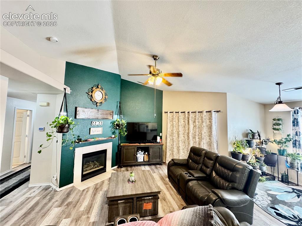 Image 12 of 32: Living area featuring vaulted ceilings, wood-finish flooring, a built-in fi