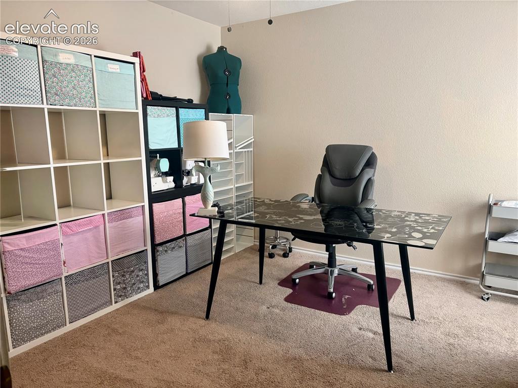 Image 15 of 32: Carpeted interior room featuring neutral wall paint, a ceiling fan, and bui