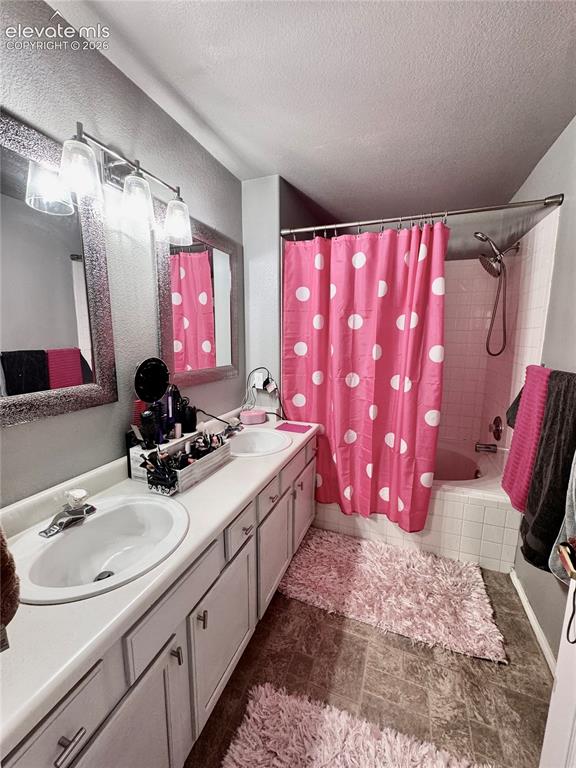 Image 19 of 32: Dual vanity with integrated sinks, brushed nickel fixtures, and a multi-lig