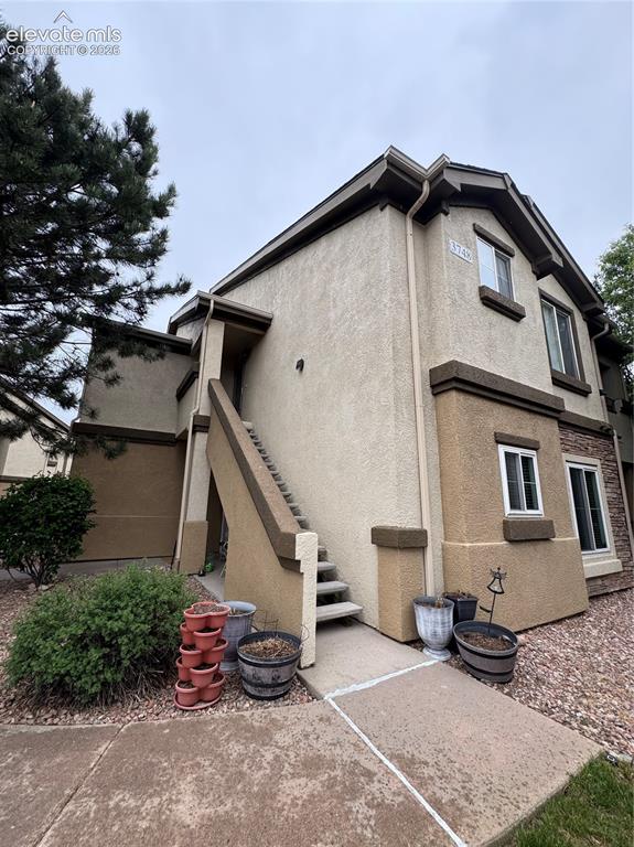 Image 2 of 32: Multi-level stucco exterior with contrasting trim accents