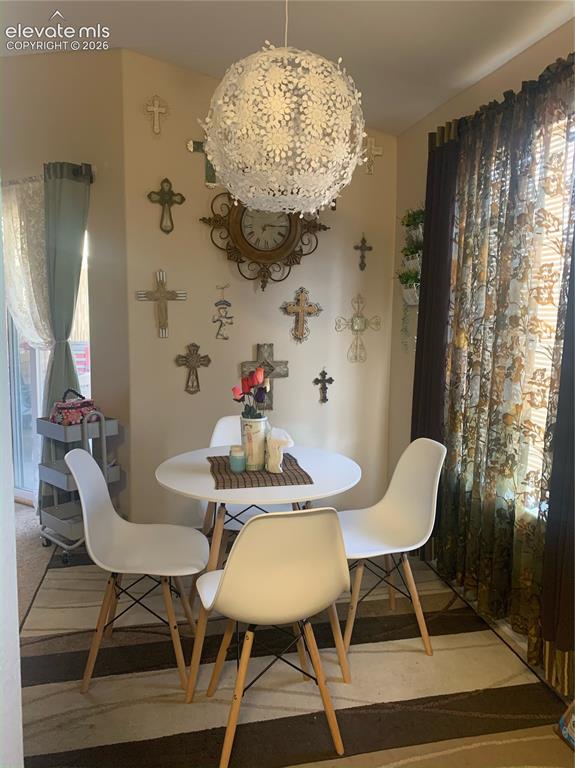 Image 24 of 32: Corner dining area featuring neutral wall tones, a circular pendant light f