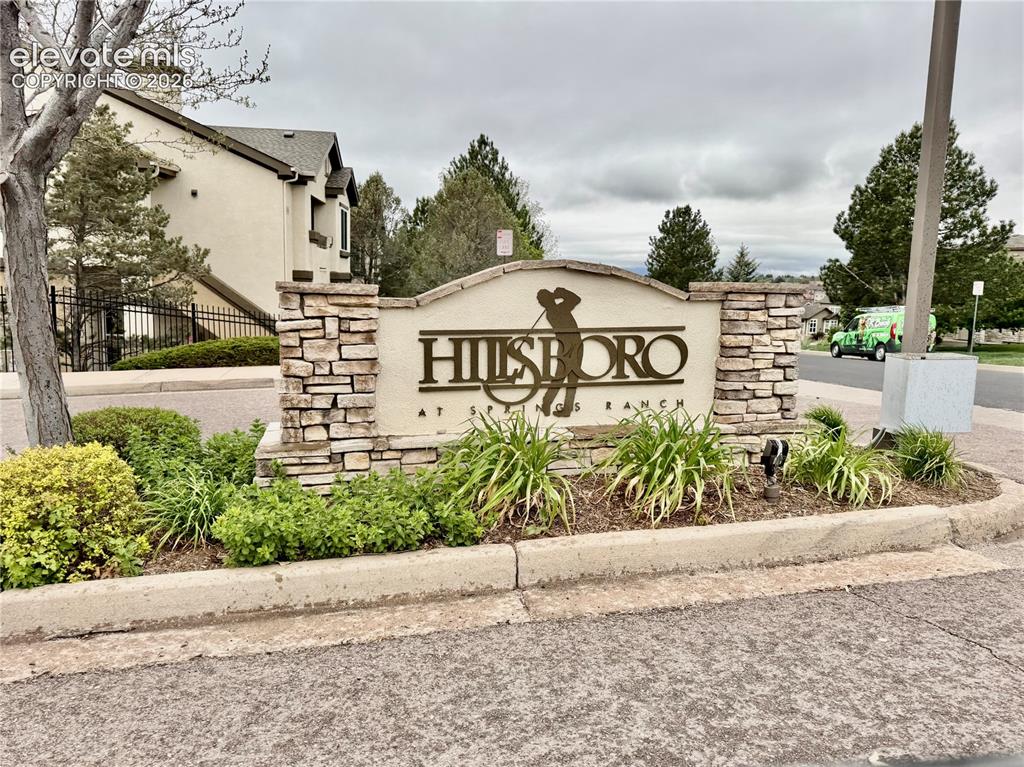 Image 26 of 32: Community entry signage featuring stone veneer columns and an arched top pa