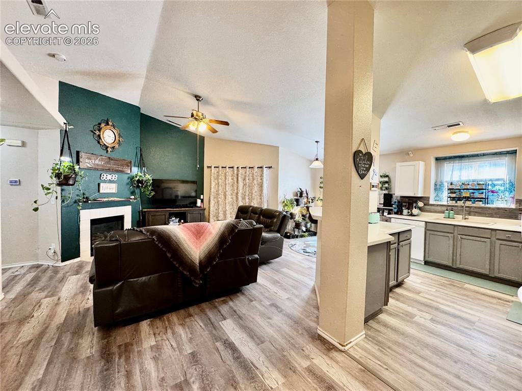 Image 3 of 32: Living area with vaulted ceilings and wood-finish flooring