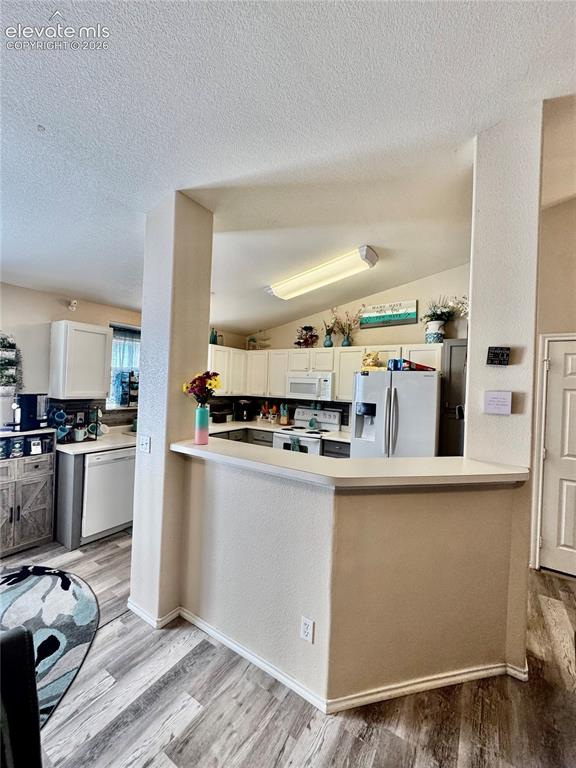 Image 5 of 32: Kitchen featuring wood-finish flooring, white cabinetry, a built-in kitchen