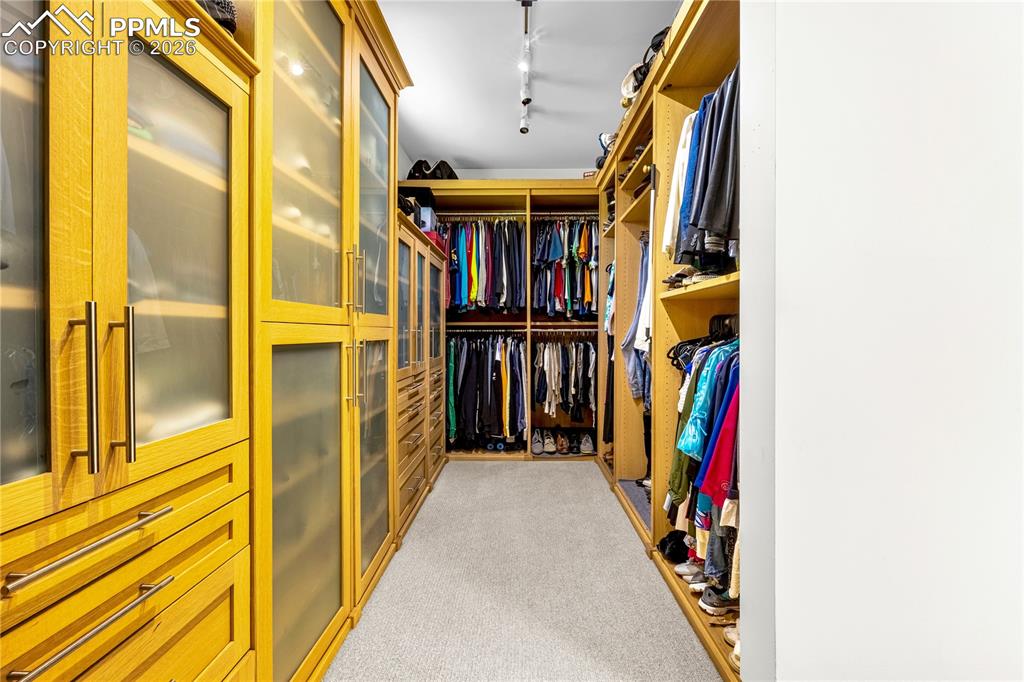 Image 29 of 48: Walk-in primary closet with built-in organization