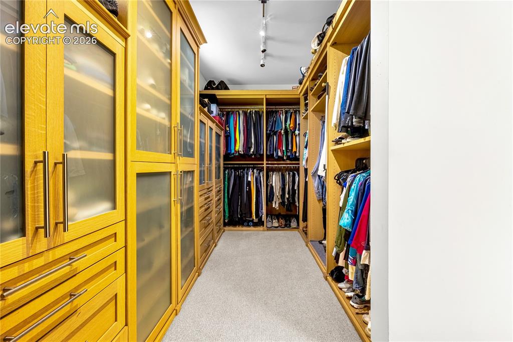 Image 30 of 49: Walk-in primary closet with built-in organization