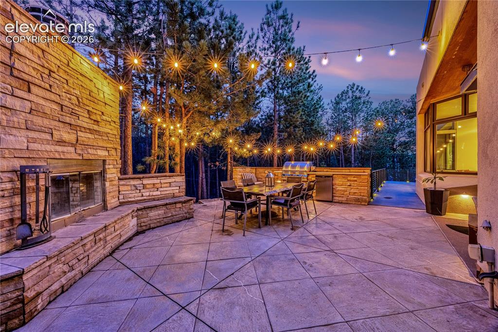 Image 6 of 48: Side patio with built-in grill & fireplace