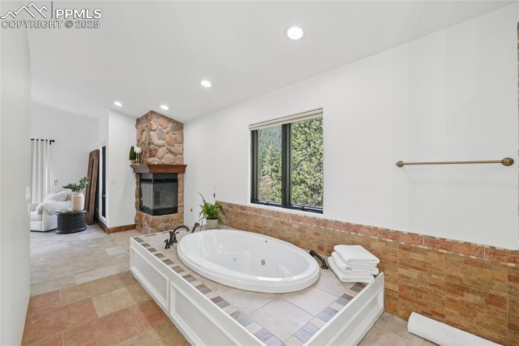 Image 26 of 50: Primary 5 piece bathroom with fireplace, walk in closet and newer vanities,