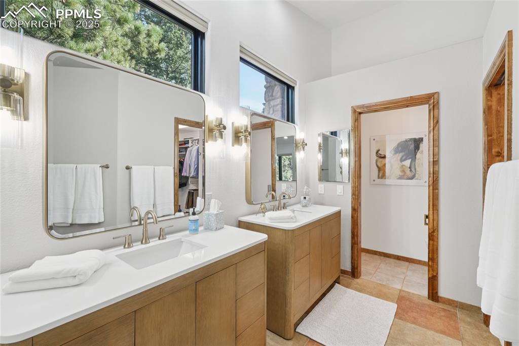 Image 27 of 50: Primary bathroom looking to the newer mirrors, light fixtures and vanities