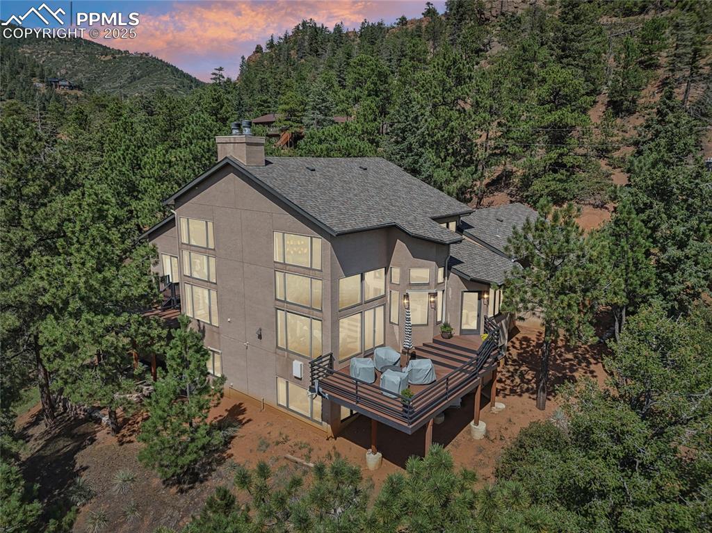 Image 49 of 50: Twilight shot of the back of the home surrounded by mountains!