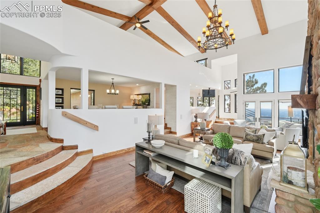 Image 8 of 50: Living room with beamed ceilings, oak flooring, two walk outs and a gas bur