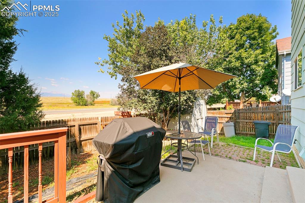 Image 28 of 29: Back patio with grill and patio, featuring mountain views and private, fenc