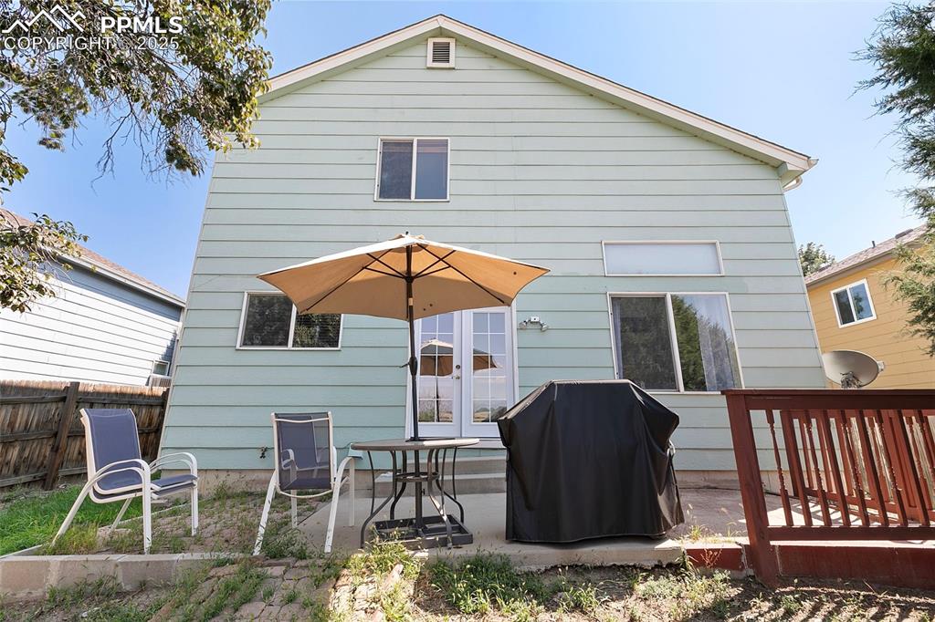 Image 29 of 29: Back of house with grill and patio, and private, fenced backyard
