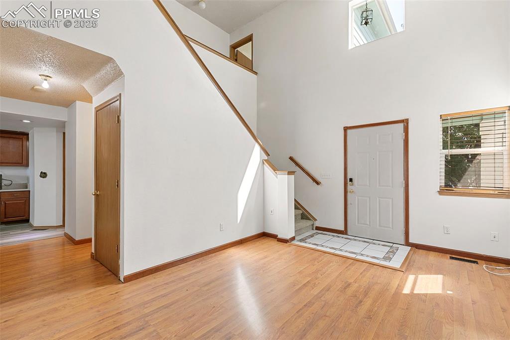 Image 5 of 29: Living Room featuring vaulted ceiling and front entry