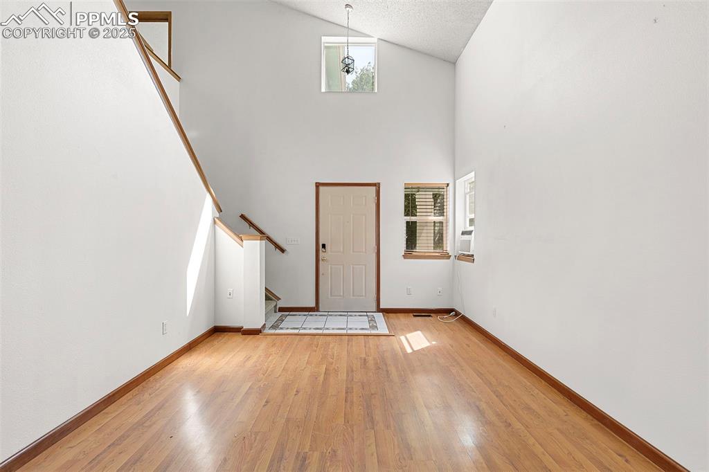 Image 6 of 29: Living Room featuring vaulted ceiling and front entry