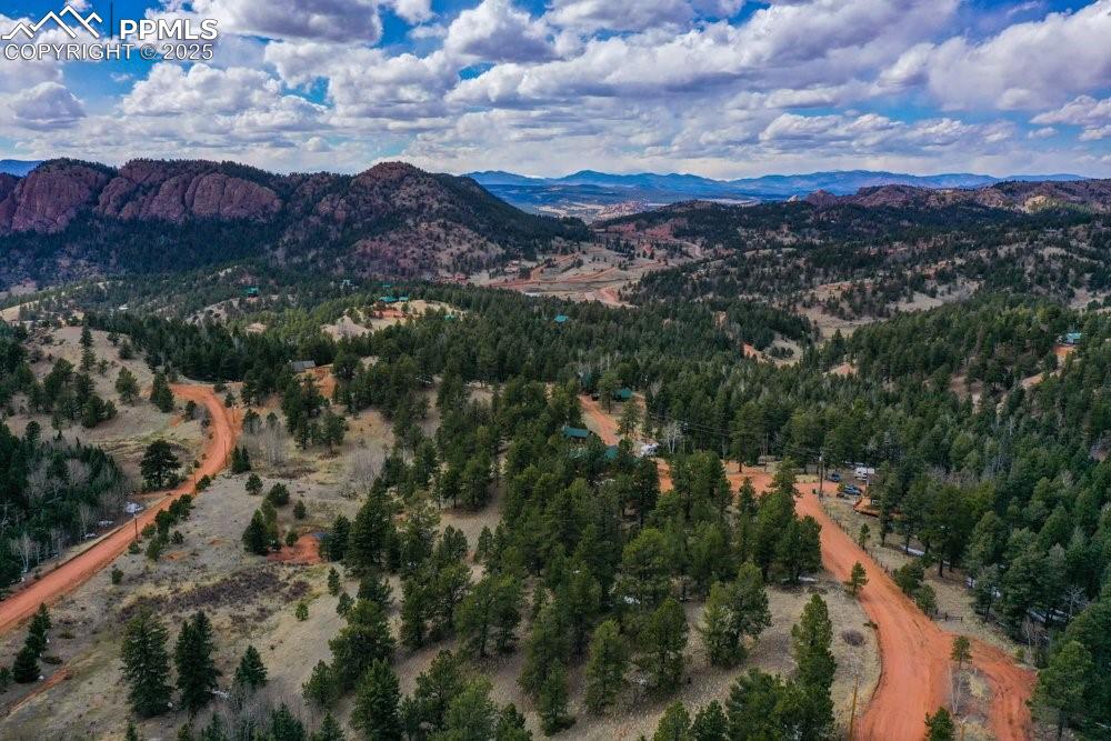 Image 16 of 39: Birds eye view of property with a mountain view and a wooded view