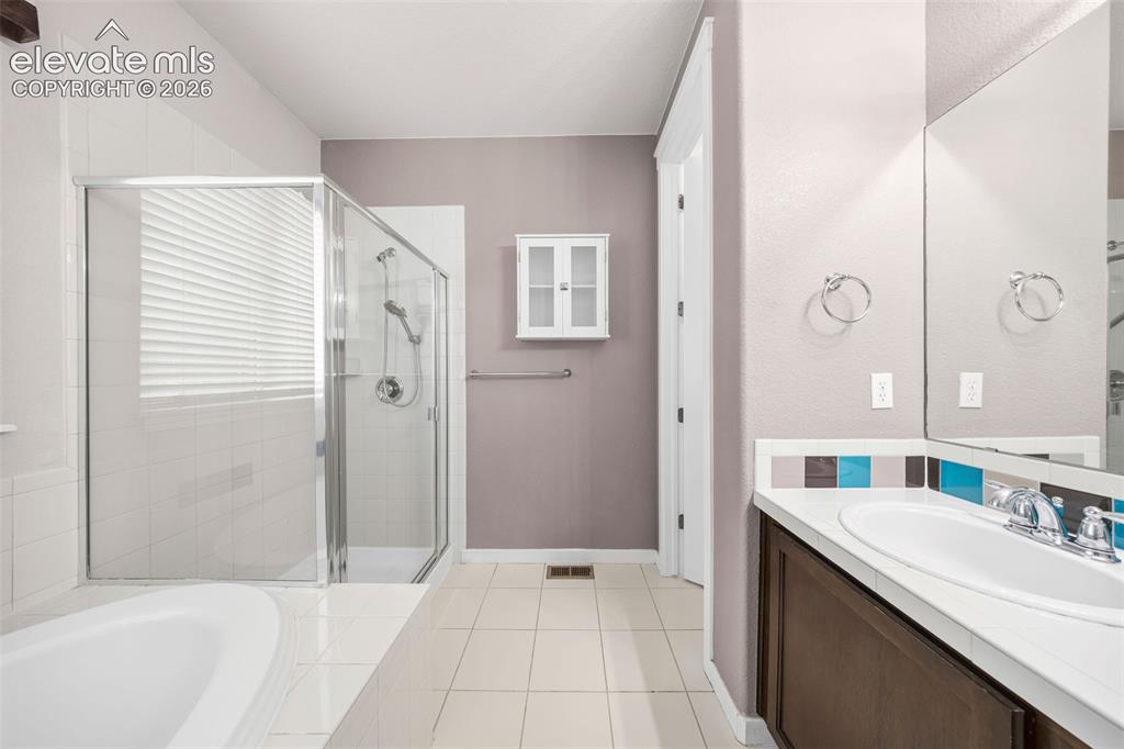 Image 23 of 39: Versatile bathroom with direct access from both a secondary bedroom and the
