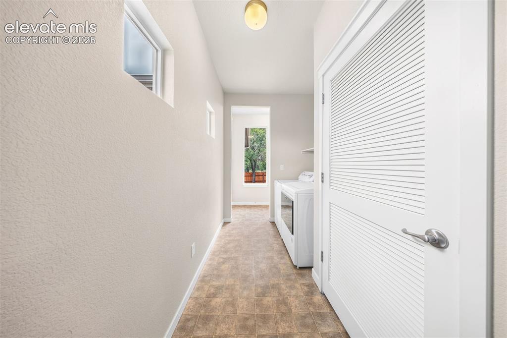 Image 30 of 39: Utility area featuring a water heater and a PEX plumbing manifold system fo