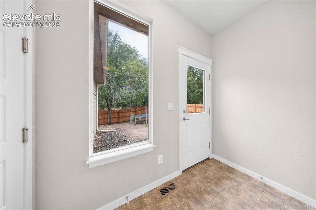 Image 33 of 39: Driveway leading to the side patio entrance and rear-set attached two-car g