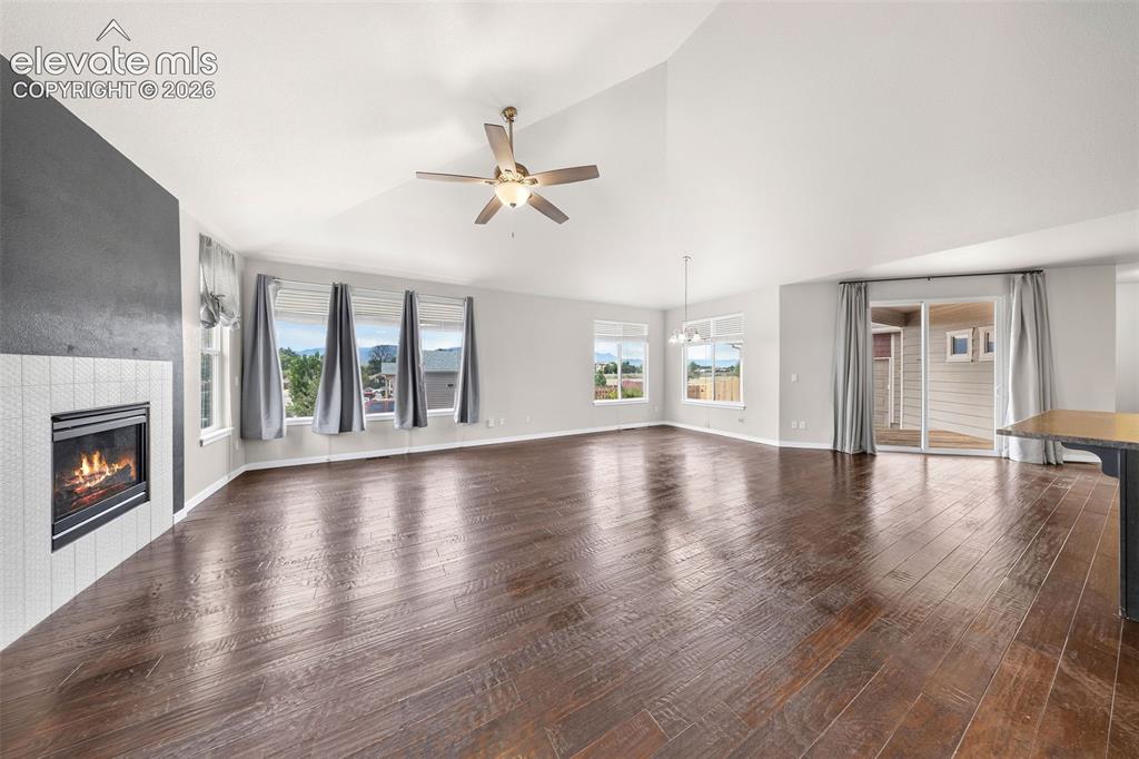 Image 8 of 39: Open-concept dining area featuring engineered wood flooring, soaring vaulte