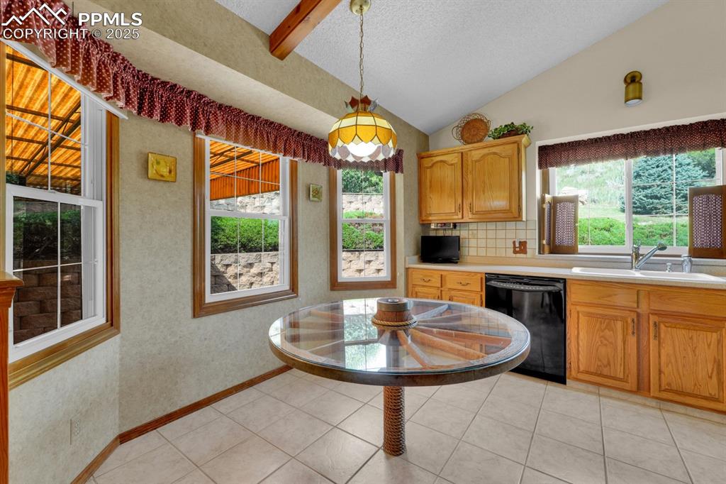 Image 10 of 47: Kitchen tile floors, black appliances and breakfast nook