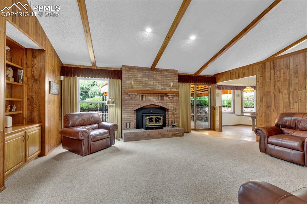 Image 2 of 47: Living area with a wood burning brick fireplace