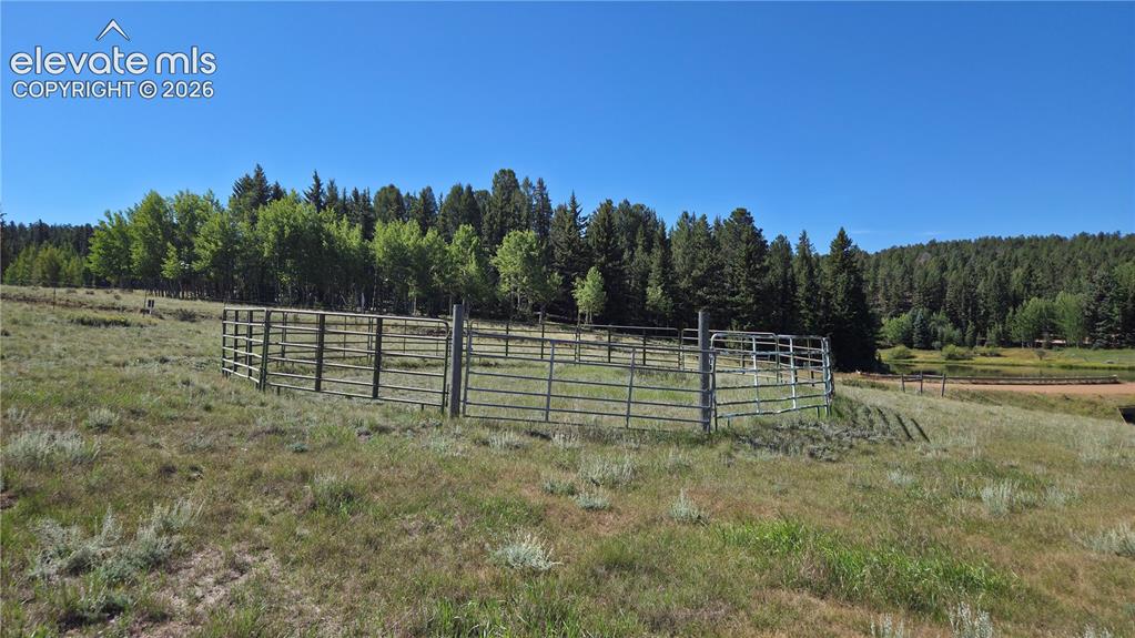 Image 12 of 35: Expansive open field featuring a circular metal fenced corral.
