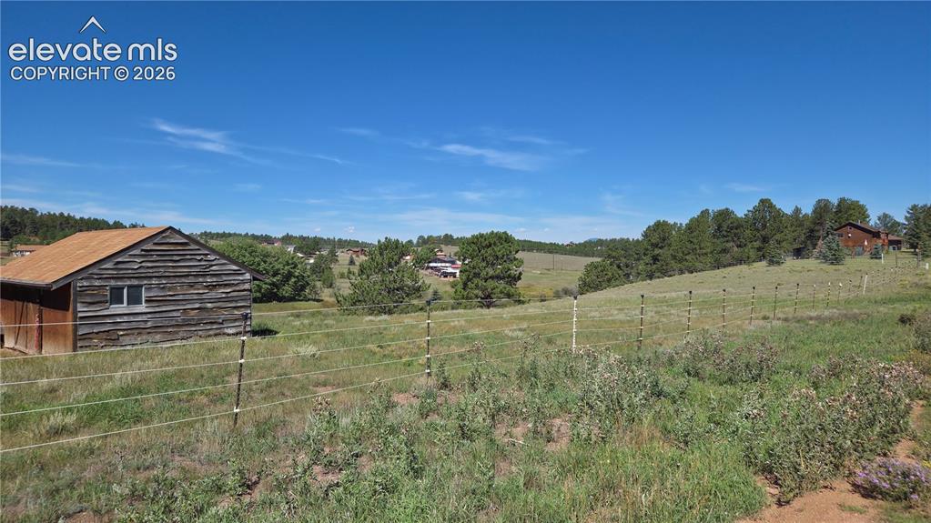 Image 15 of 35: Horse barn, fencing and distant neighbors.