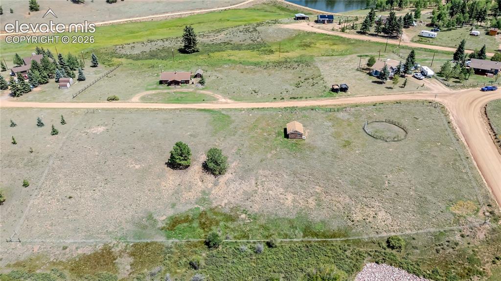 Image 18 of 35: Expansive open acreage with horse stall and corral.