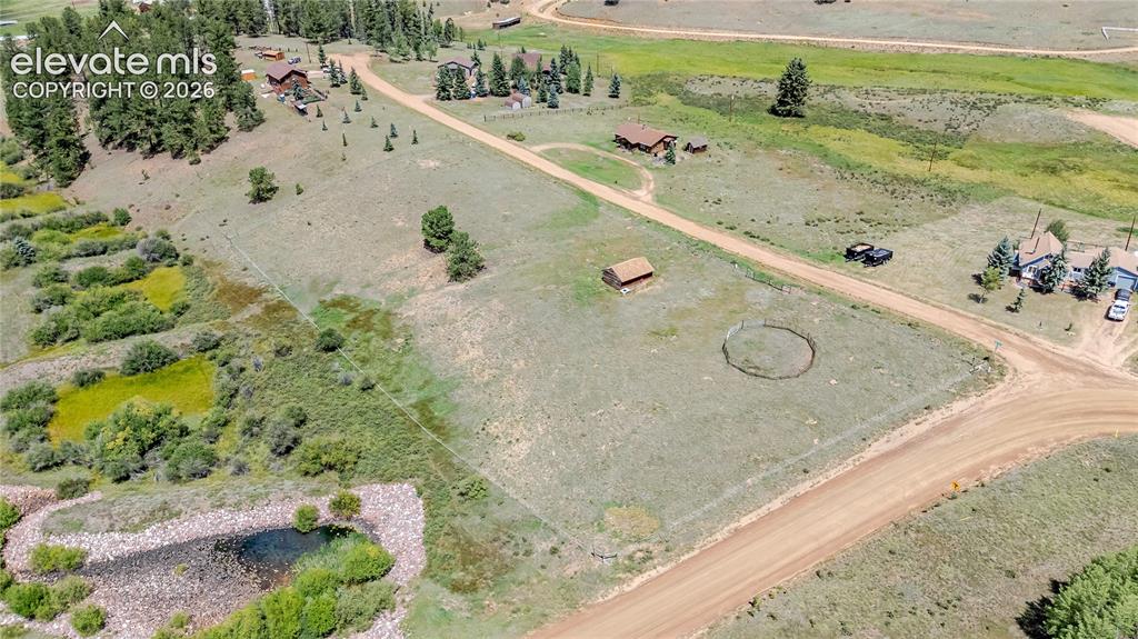 Image 22 of 35: Expansive lot featuring a fenced pasture, a dirt road, a small outbuilding,