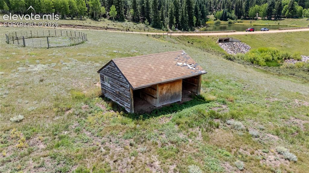 Image 25 of 35: Two horse stall and corral on gently sloping acreage.