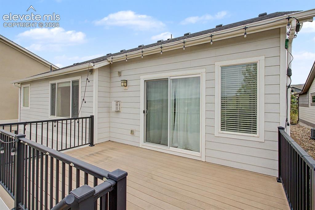 Image 21 of 44: Expansive outdoor deck featuring composite wood-finish flooring and black m
