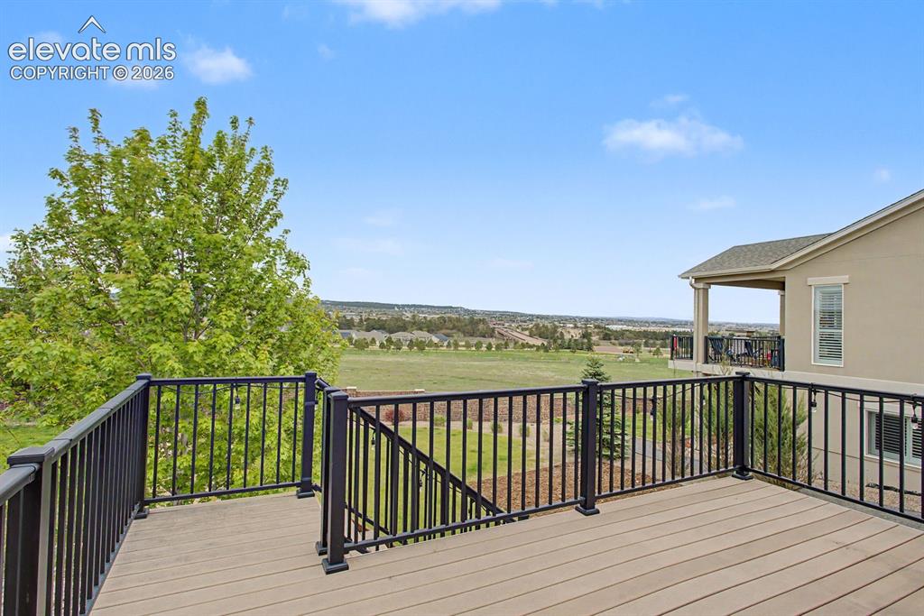 Image 22 of 44: Spacious outdoor deck with composite decking and black metal railings