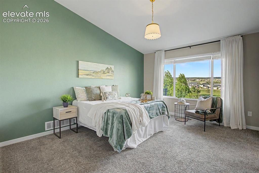 Image 24 of 44: Bedroom featuring a prominent window, sloped ceiling, light green accent wa